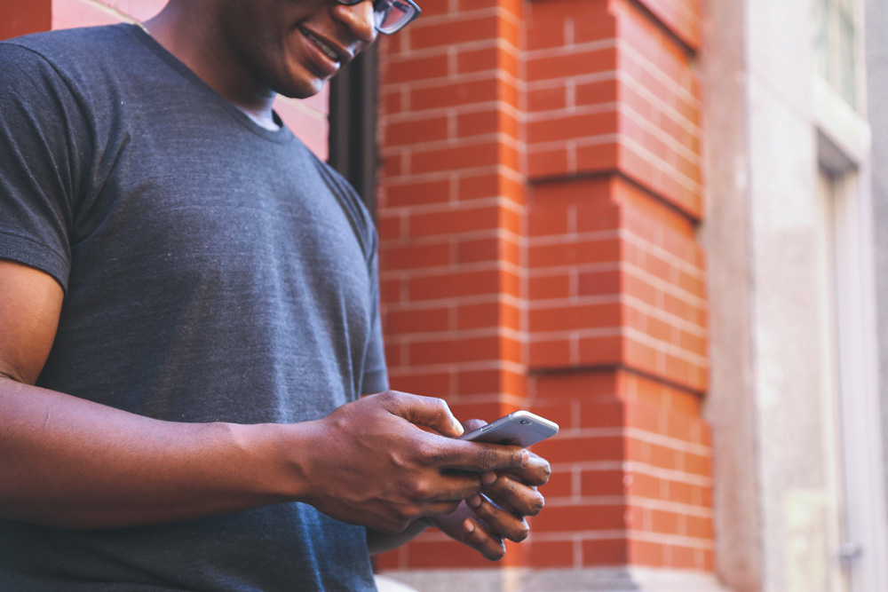 man checking mobile phone on the sidewalk